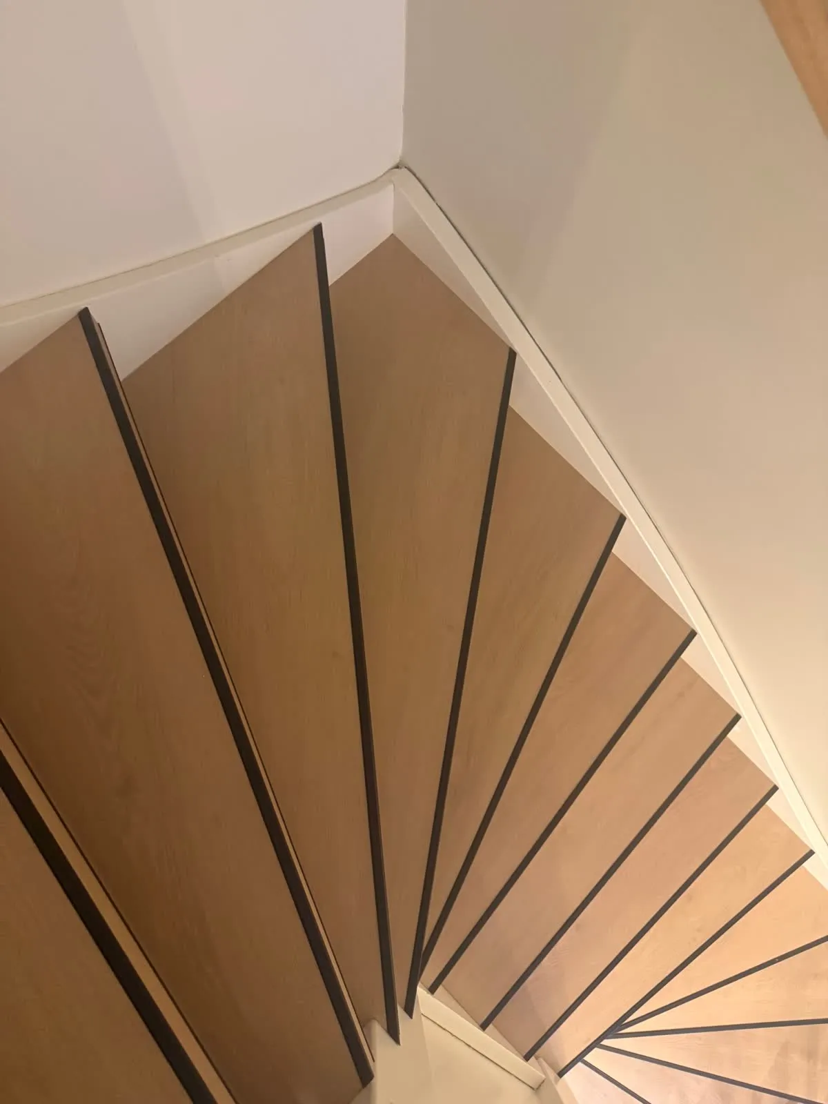 Draaiende trap gerenoveerd met licht eiken houtdecor