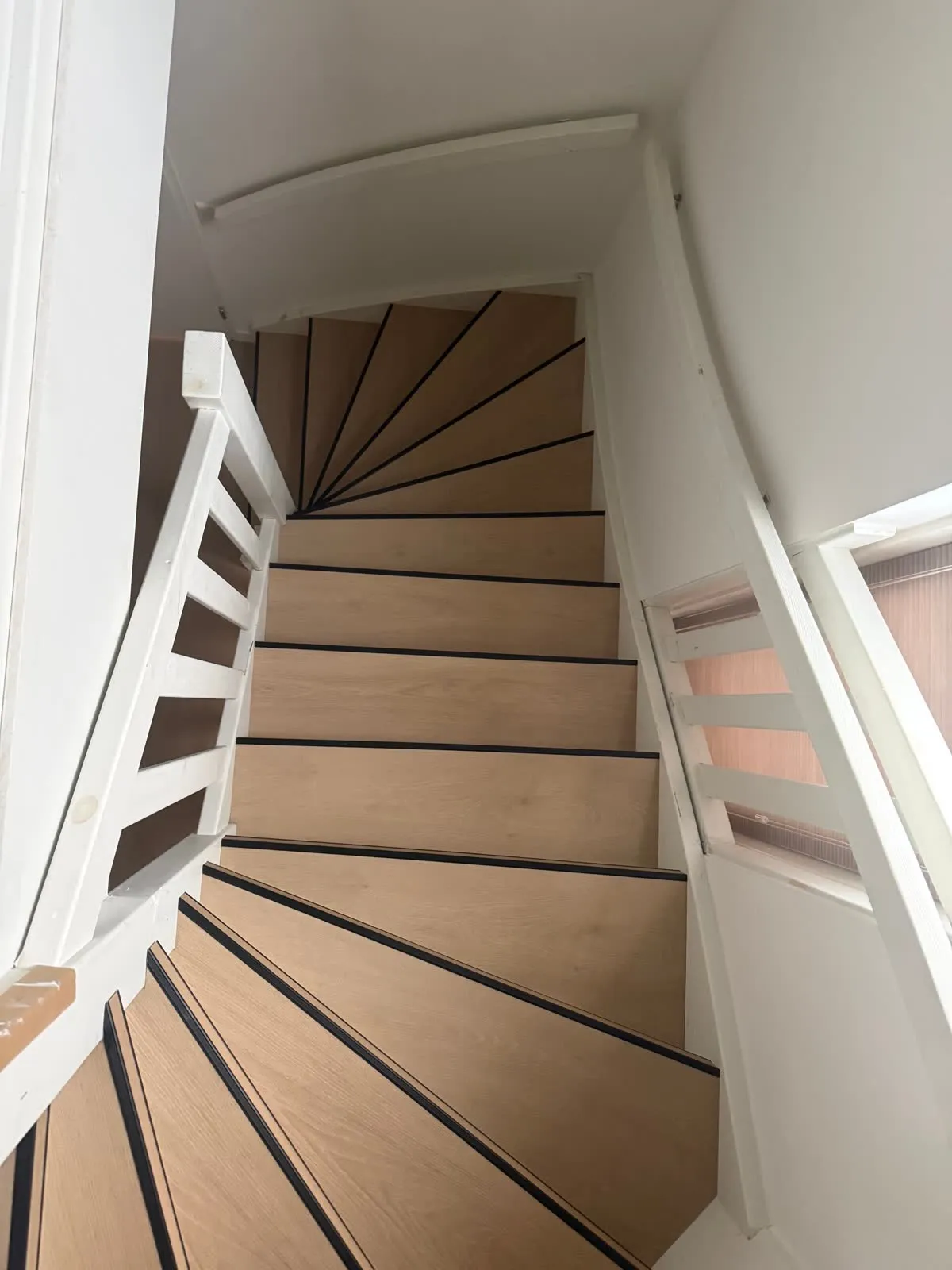 Draaiende trap gerenoveerd met licht eiken houtdecor