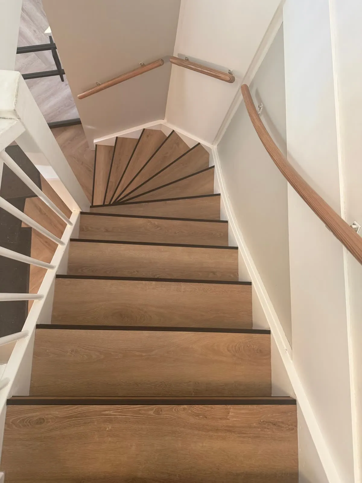 Draaiende trap gerenoveerd met licht eiken houtdecor