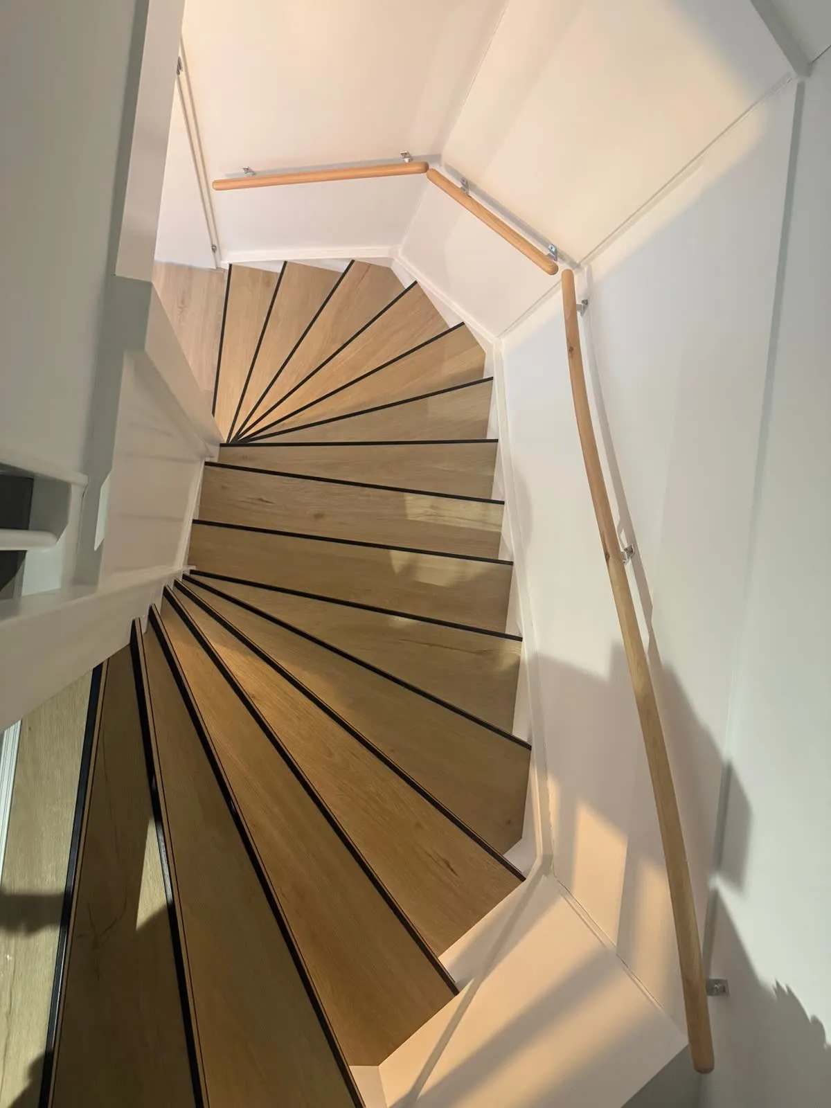 Draaiende trap gerenoveerd met licht eiken houtdecor